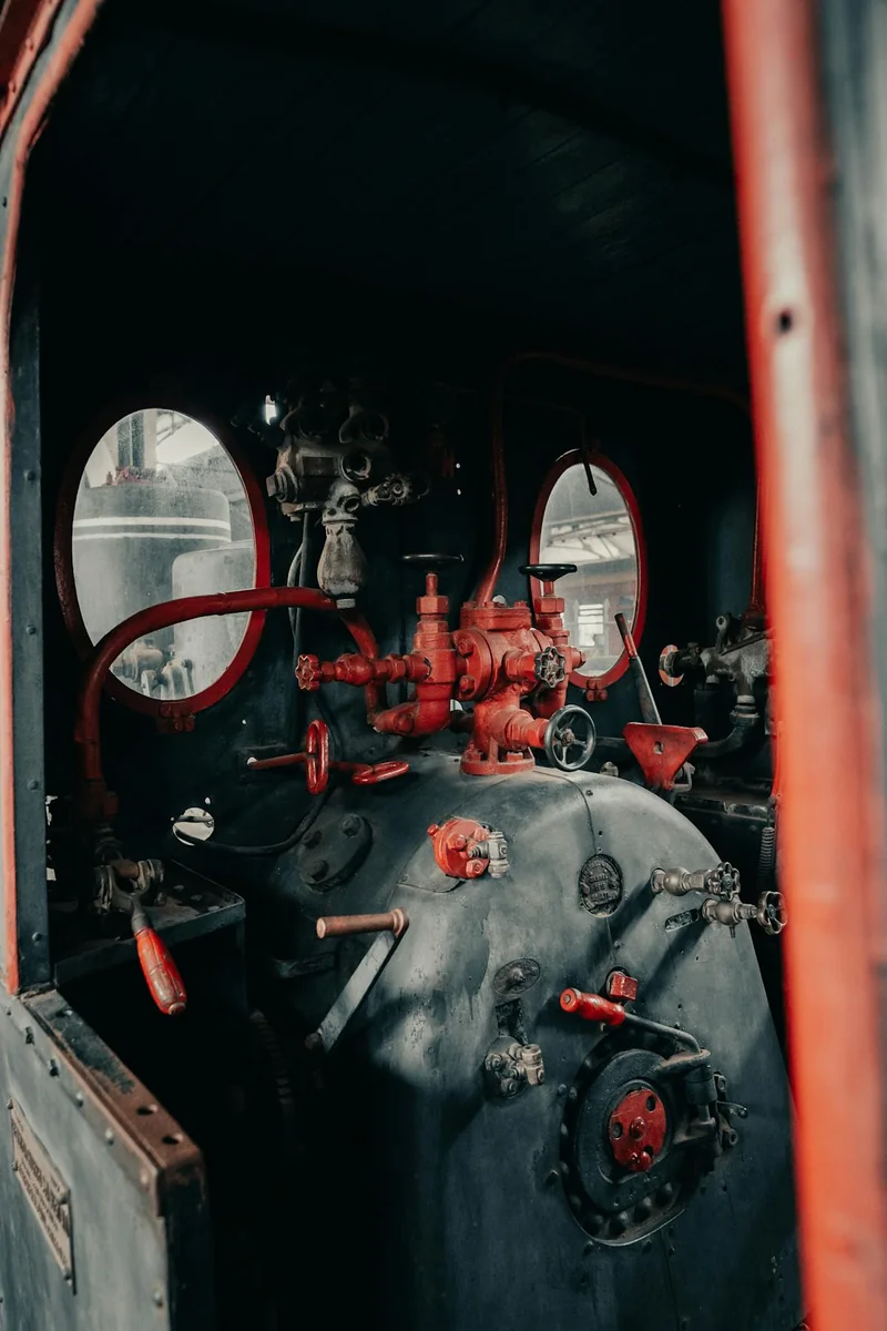 Vintage steam locomotive at rest in a depot, soft morning light, no steam rising, brass and iron gleaming quietly