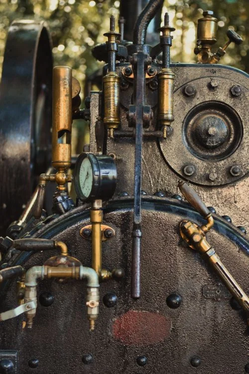 Antique steam engine machinery — brass pipes and industrial mechanisms