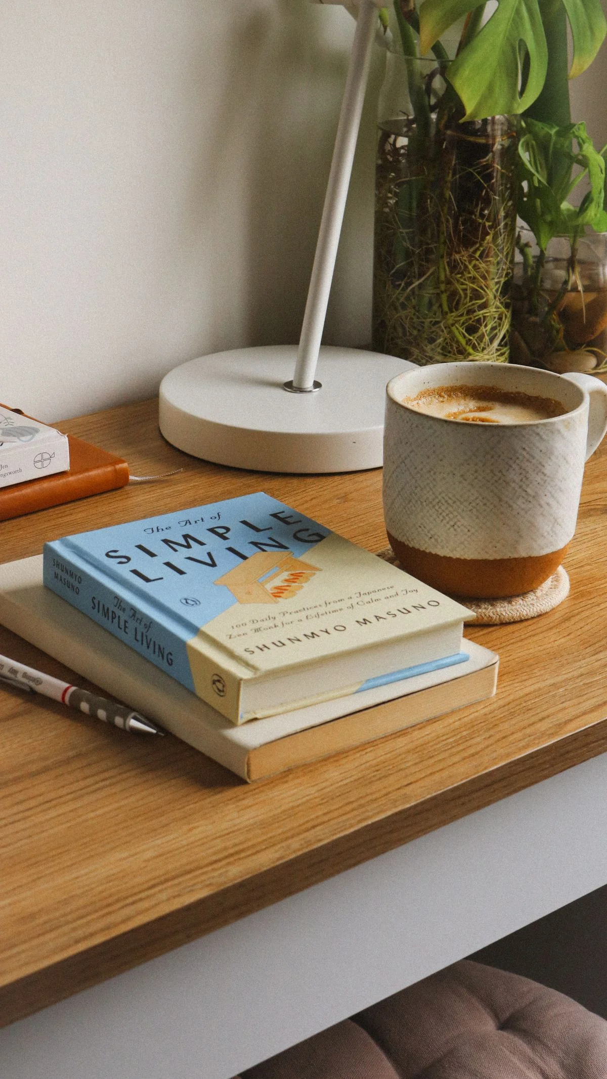 A cozy desk setup with books, a warm cup of coffee, and morning light streaming across worn wood