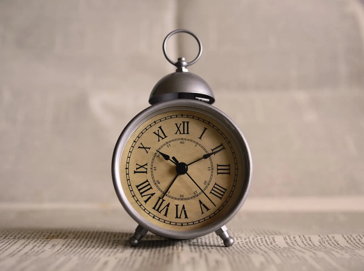 An antique clock face illuminated by soft afternoon light — the hands frozen in their eternal positions, time suspended in the warmth of a late Sunday