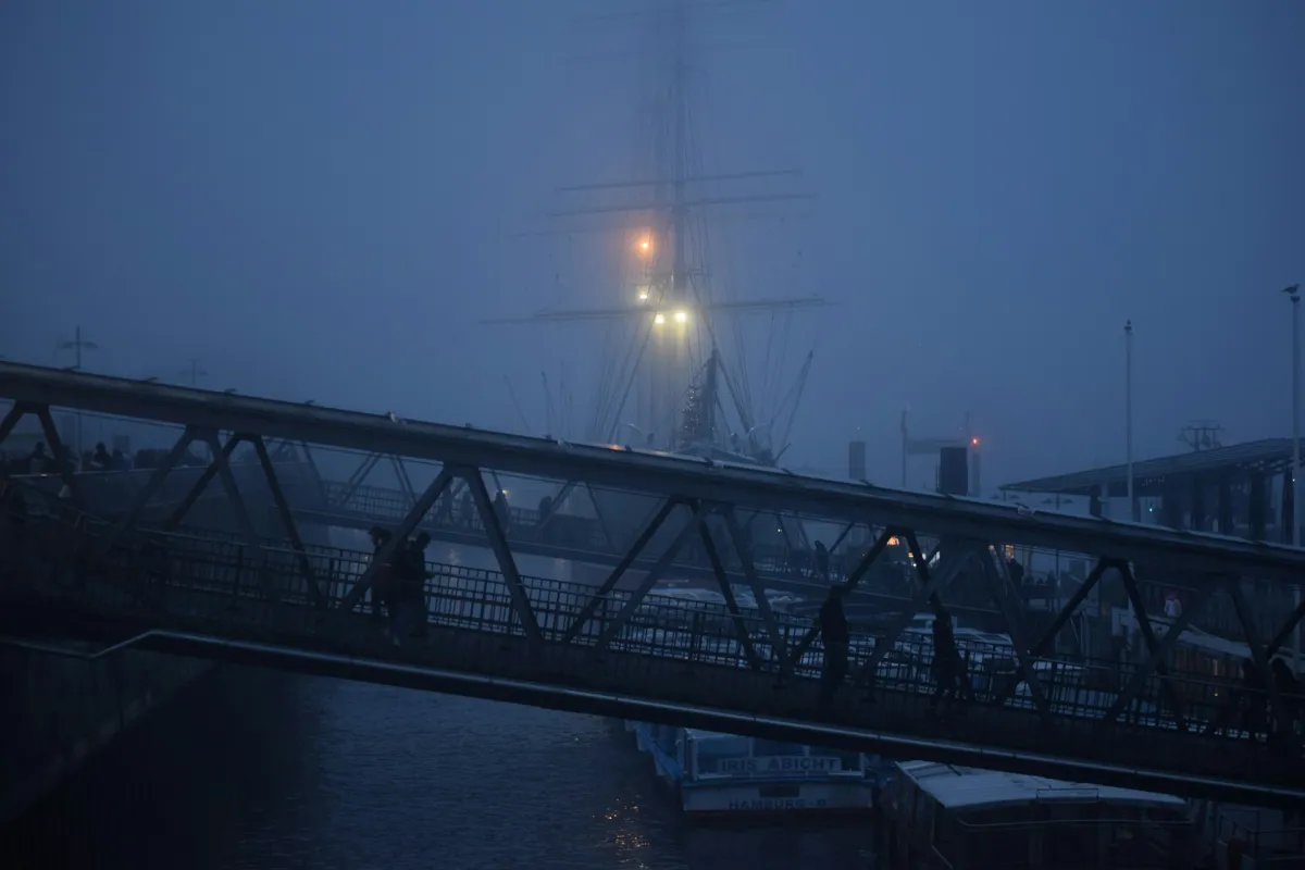 Full moon over a foggy harbor with silhouetted cranes