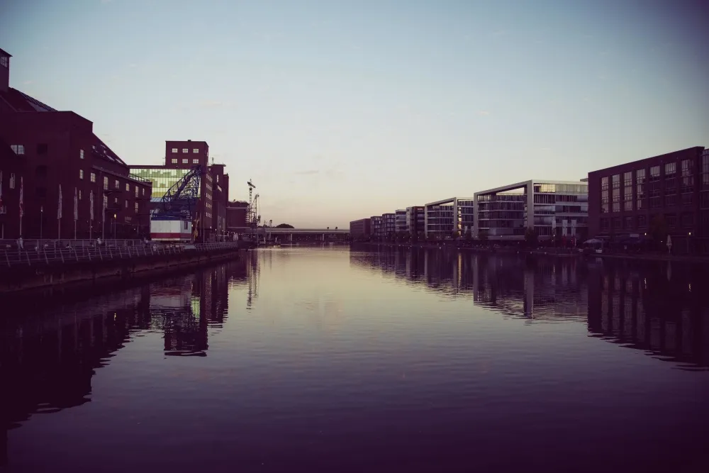 City lights reflected on dark water at night — the surface that shows you what you want to see