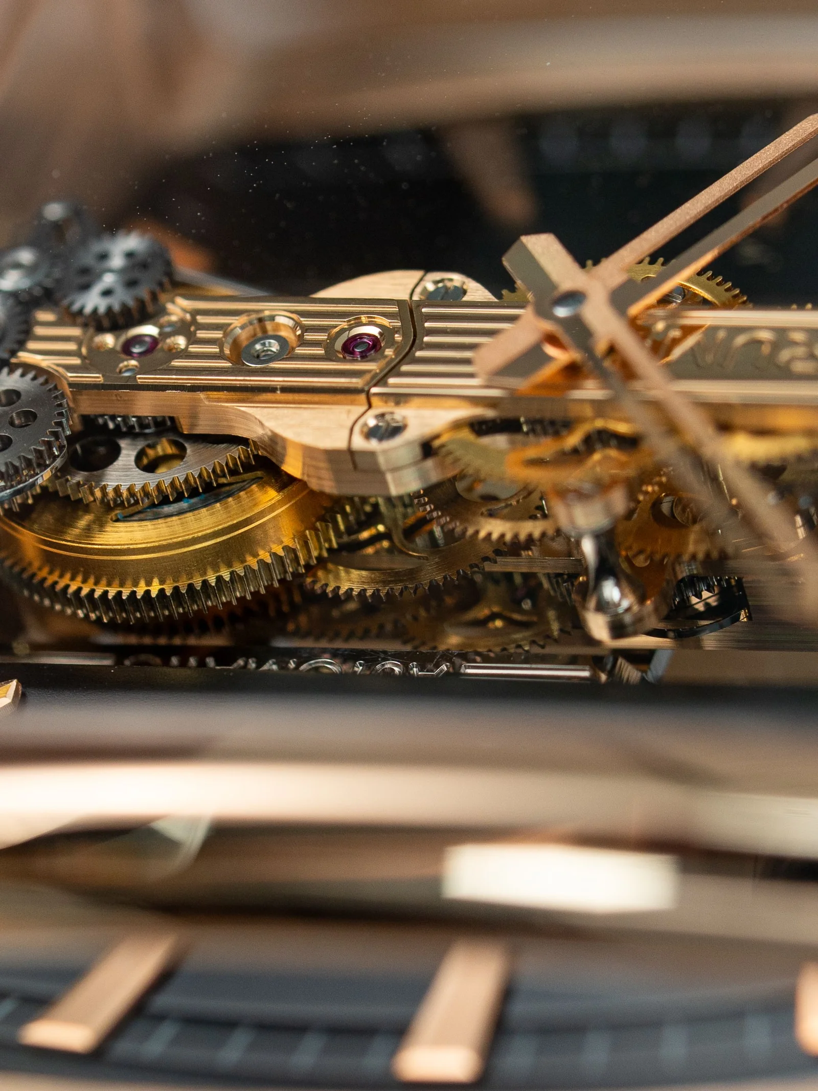 Close-up of brass watch gears and jewel bearings — tiny mechanisms within mechanisms
