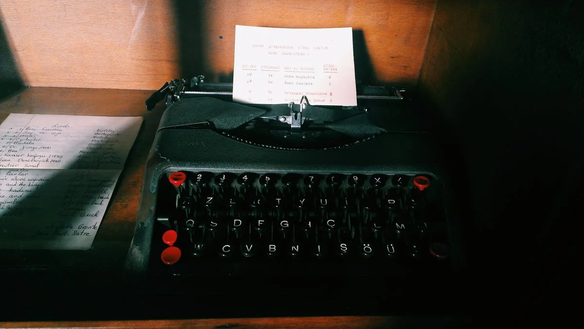 An old manual typewriter in warm afternoon light, the keys still and the page half-typed