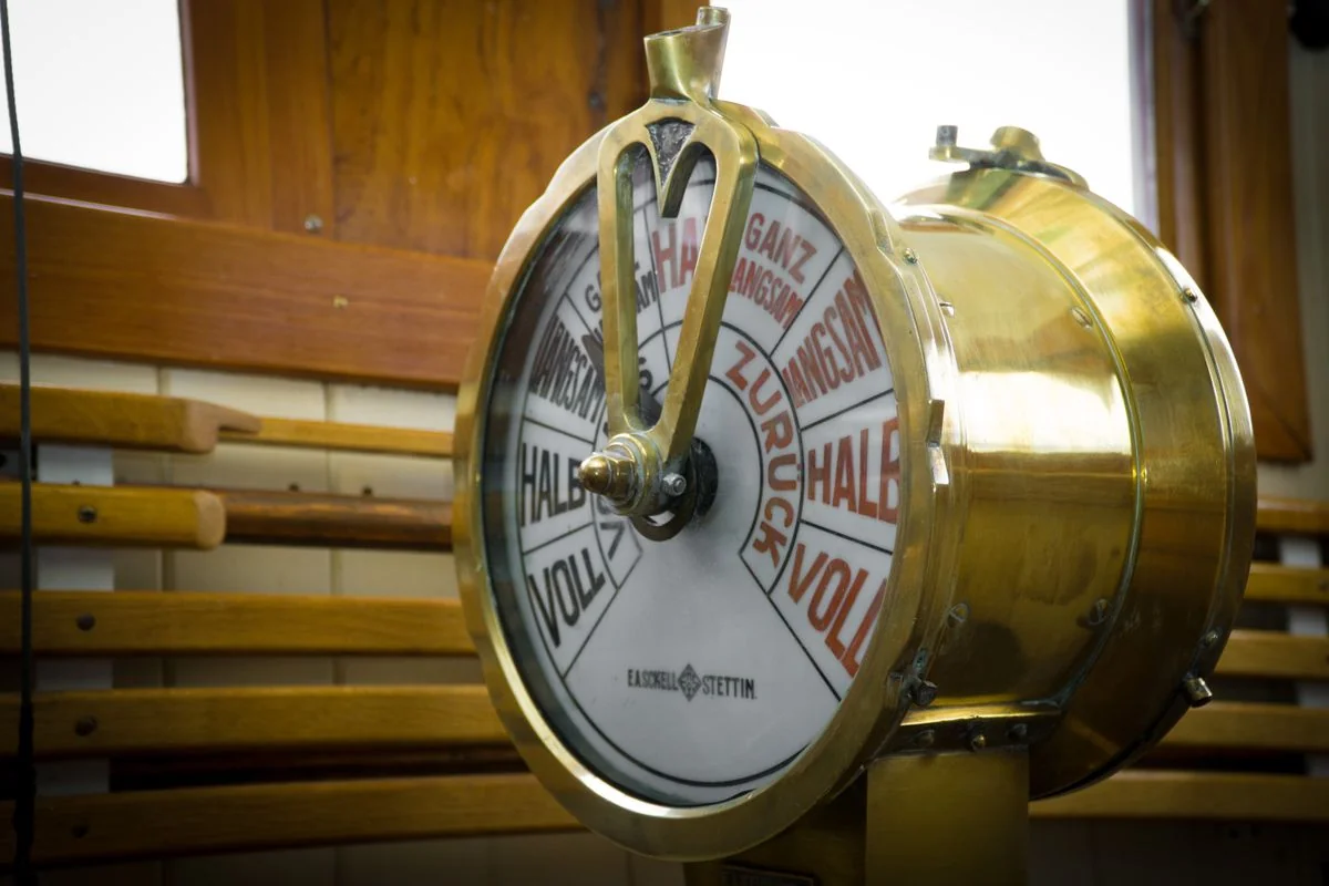 A vintage brass telegraph key on a worn wooden desk, the instrument of a message sent and received